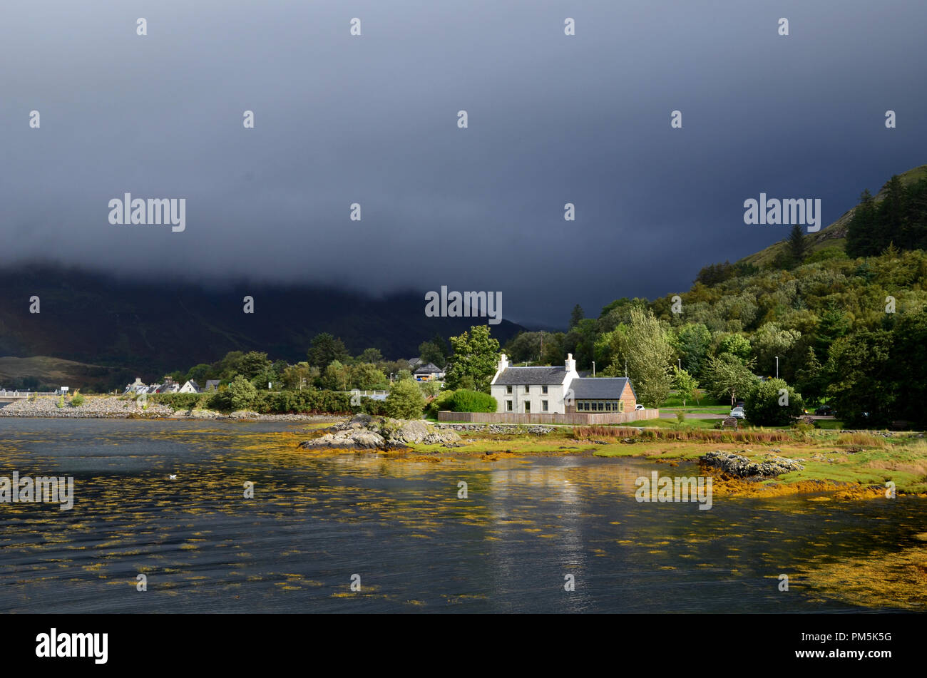Dark skies in Kyle of Lochalsh with a cute house on the shore Stock