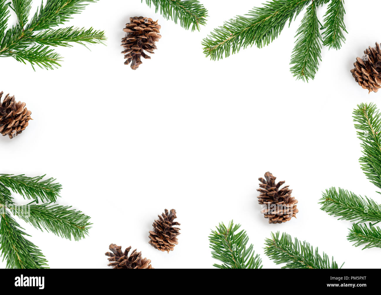 Merry Christmas layout composition, top view with fir tree branches and pine cones on a white background. Stock Photo
