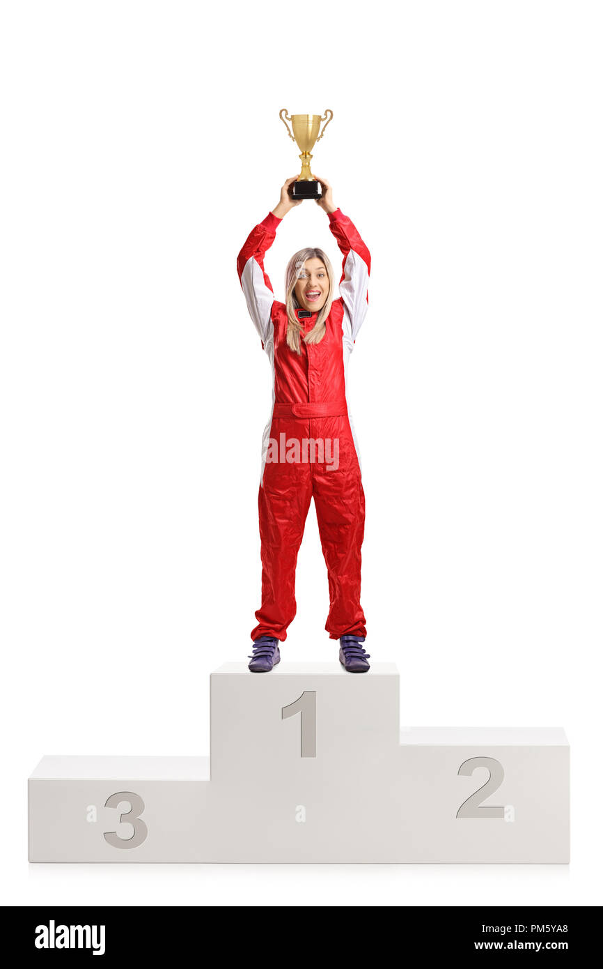 Happy female racer celebrating win on a winner's pedestal with a gold trophy cup isolated on white background Stock Photo