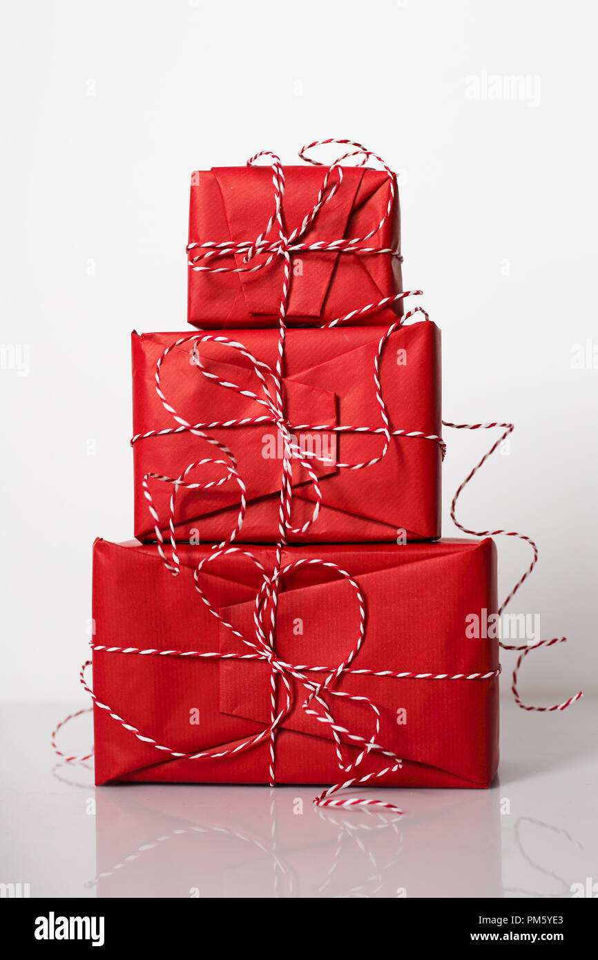 Christmas gift boxes wrapped in red paper and bow of dtriped rope on ...