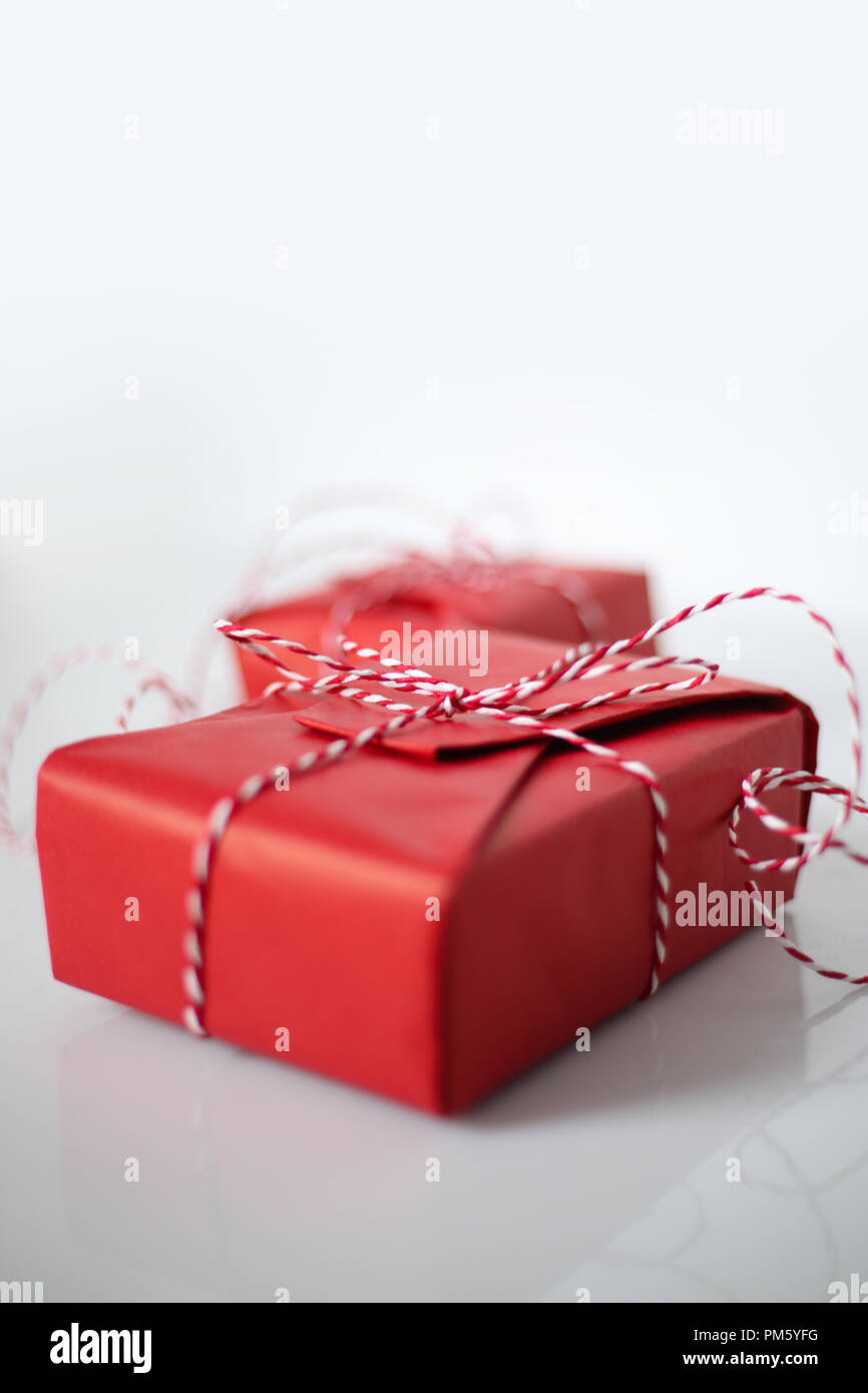 Christmas gift boxes wrapped in red paper and bow of dtriped rope on ...