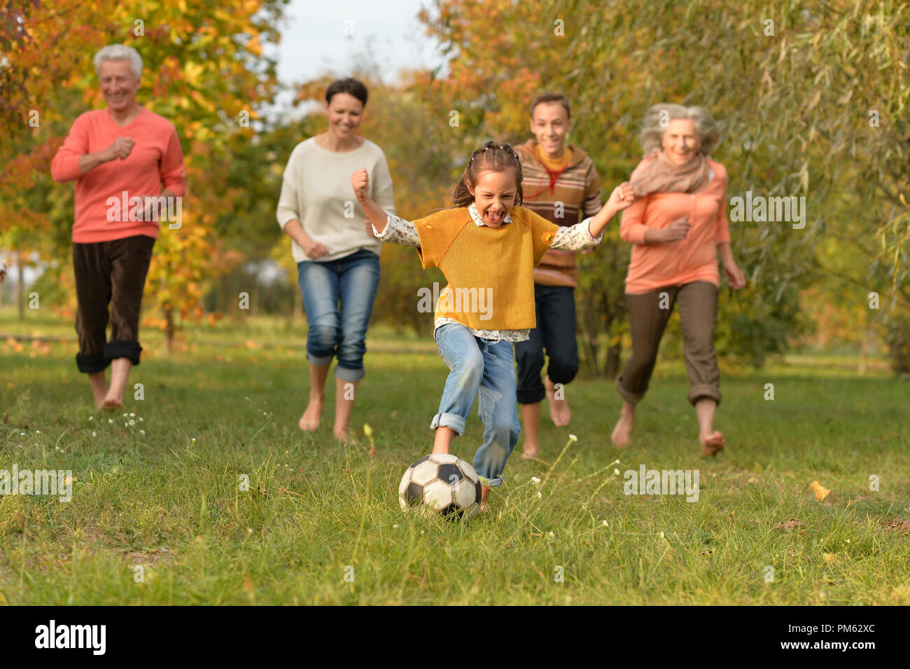 Big happy family playing football in park Stock Photo - Alamy