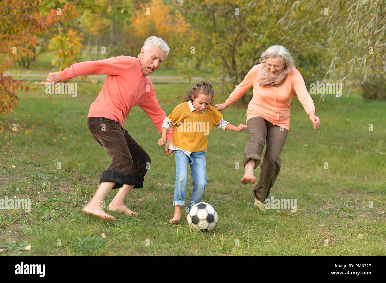 Big happy family playing football in park Stock Photo - Alamy