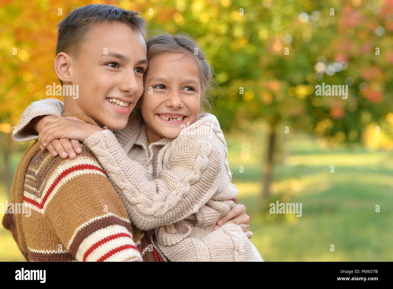 Portrait of sister and brother hugging in the park hi-res stock ...