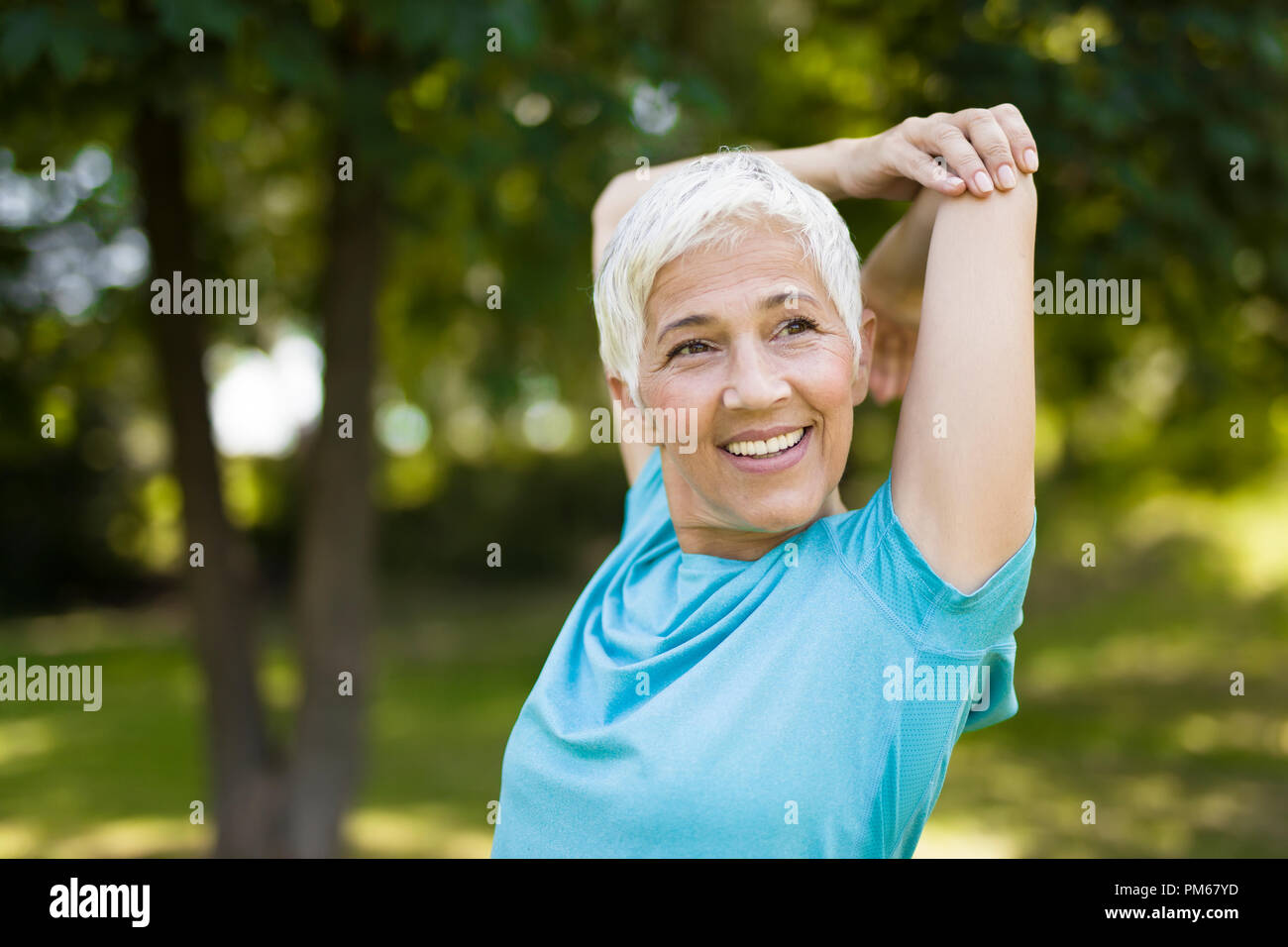 Older woman stretching arms hi-res stock photography and images - Alamy