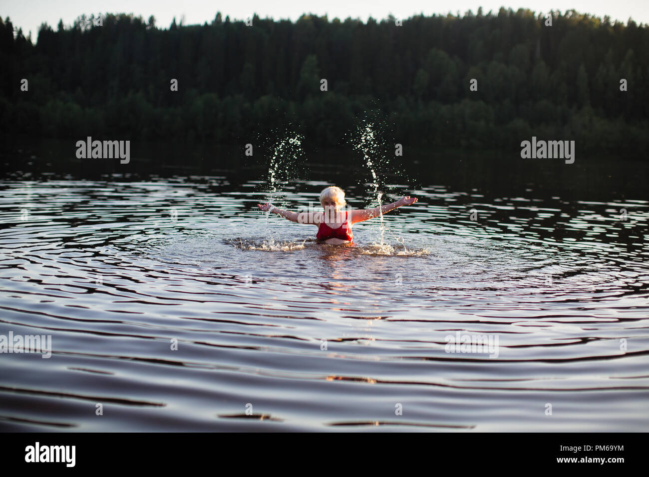 Elderly woman splashing in the summer river at village Stock Photo - Alamy