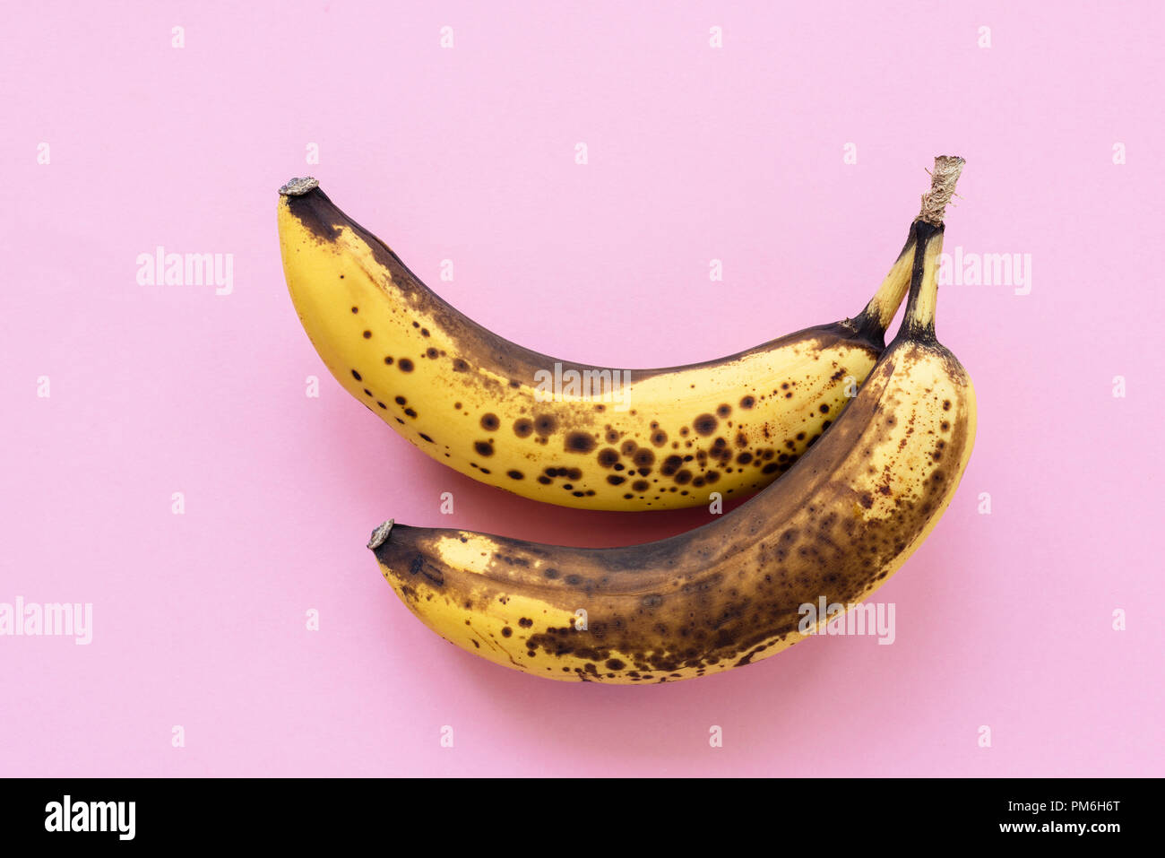 Overripe bananas on pink background, horizontal, top view Stock Photo