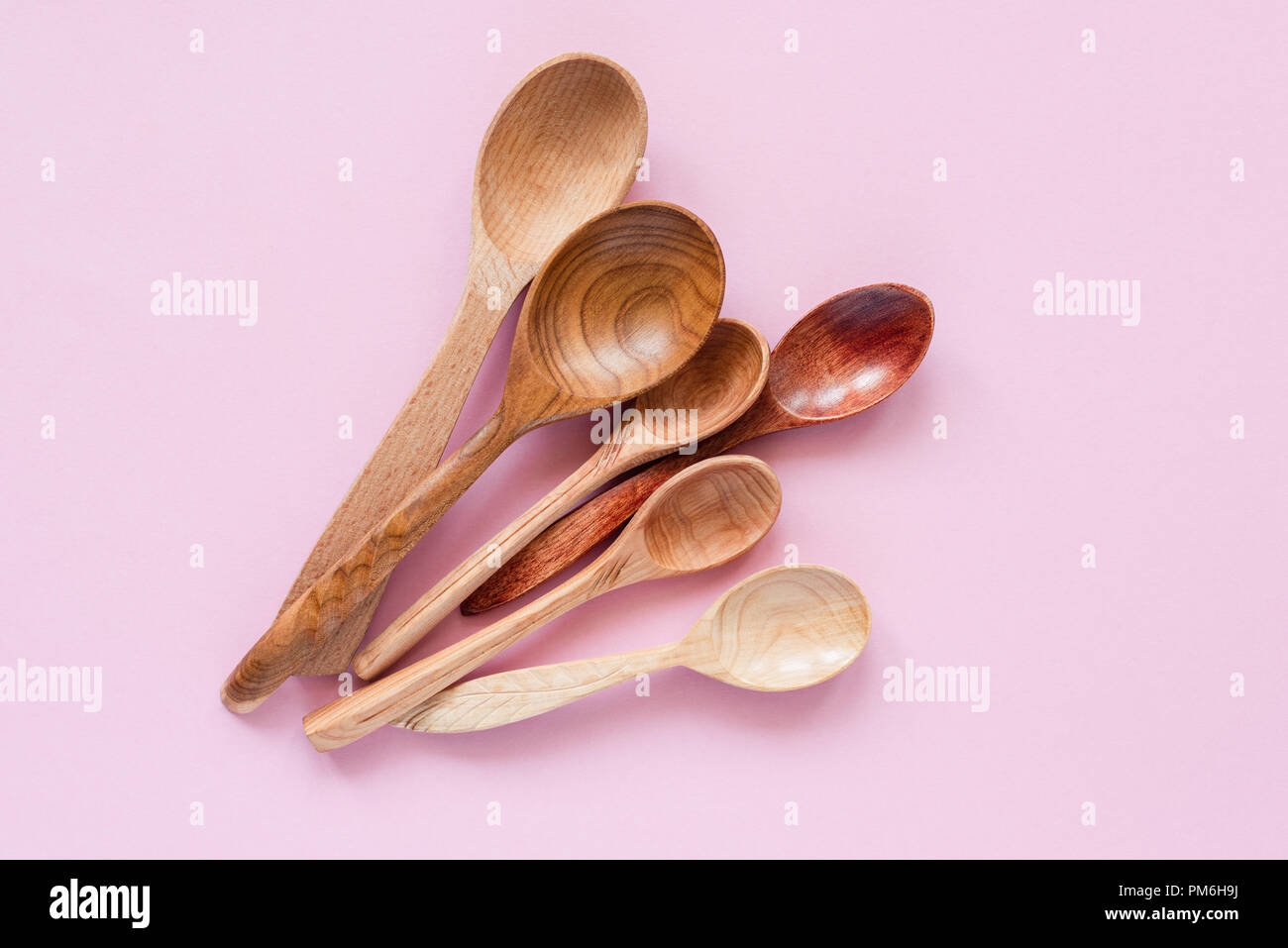 Wooden Spoons On Pink Background. Trendy Kitchen Utensils, Environmentally Friendly Eco Bamboo Spoons Stock Photo