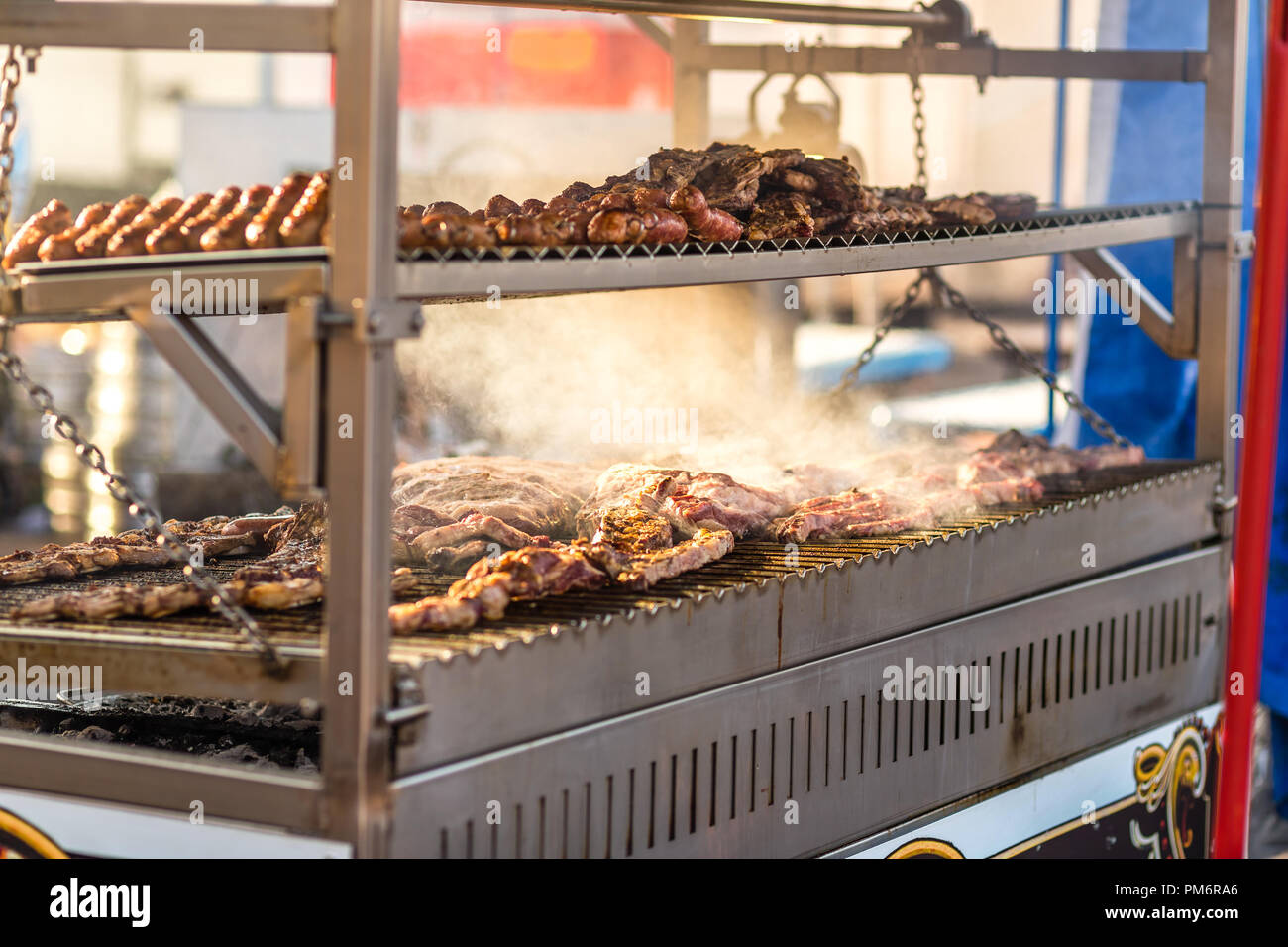 Argentinian Meat is smoking while baking on the grill in a street