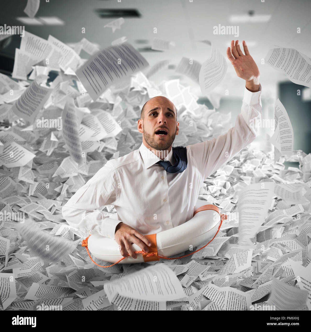 Businessman with lifebuoy sinks between worksheets in office Stock Photo