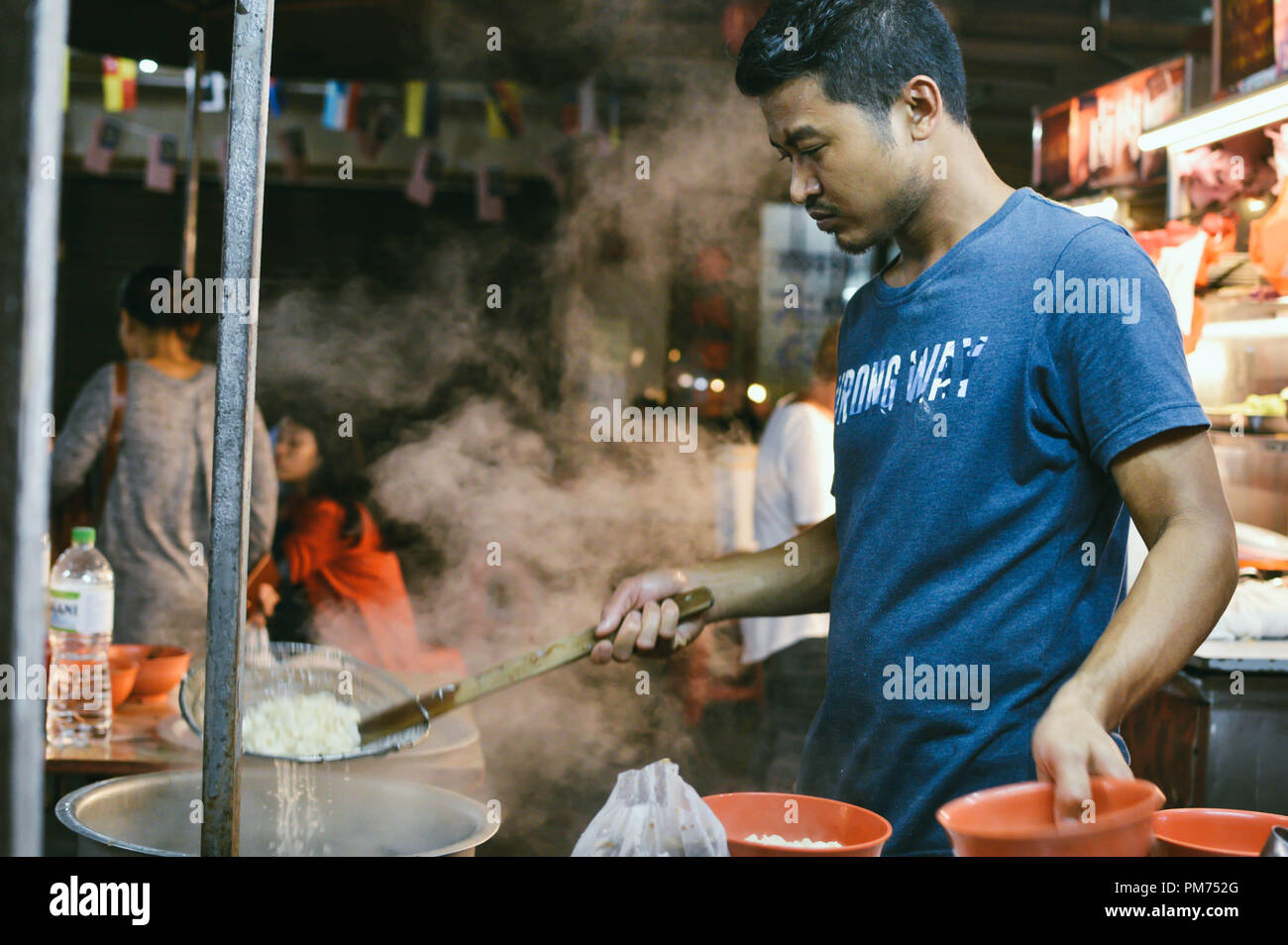 Kuala Lumpur, Malaysia - 10 September, 2017: Chinese street chef cooks traditional spicy flat noodles soup in the streets of Kuala Lumpur, Malaysia Stock Photo
