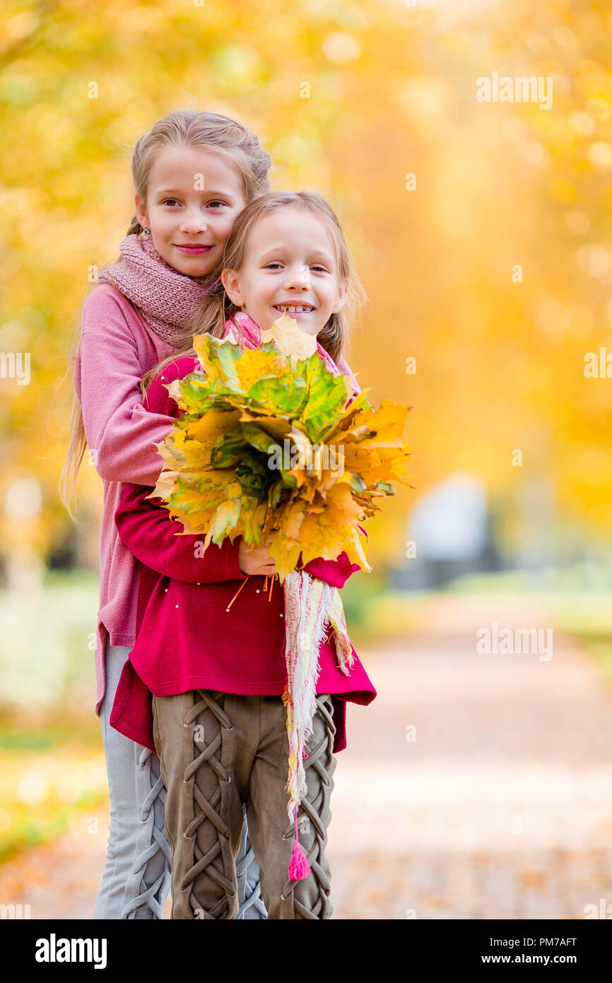 Little adorable girls at warm day in autumn park outdoors Stock Photo ...
