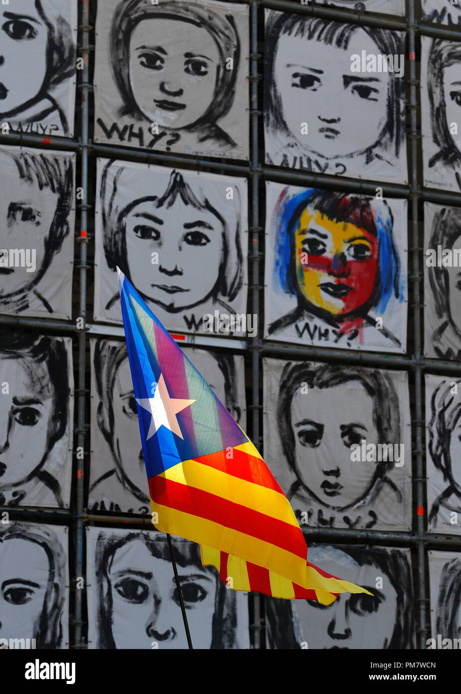 An Estelada, Catalan National flag,  waves next to a wall art by artist Carme Sole in Barcelona during their Diada, a yearly Catalan Nationalism day Stock Photo