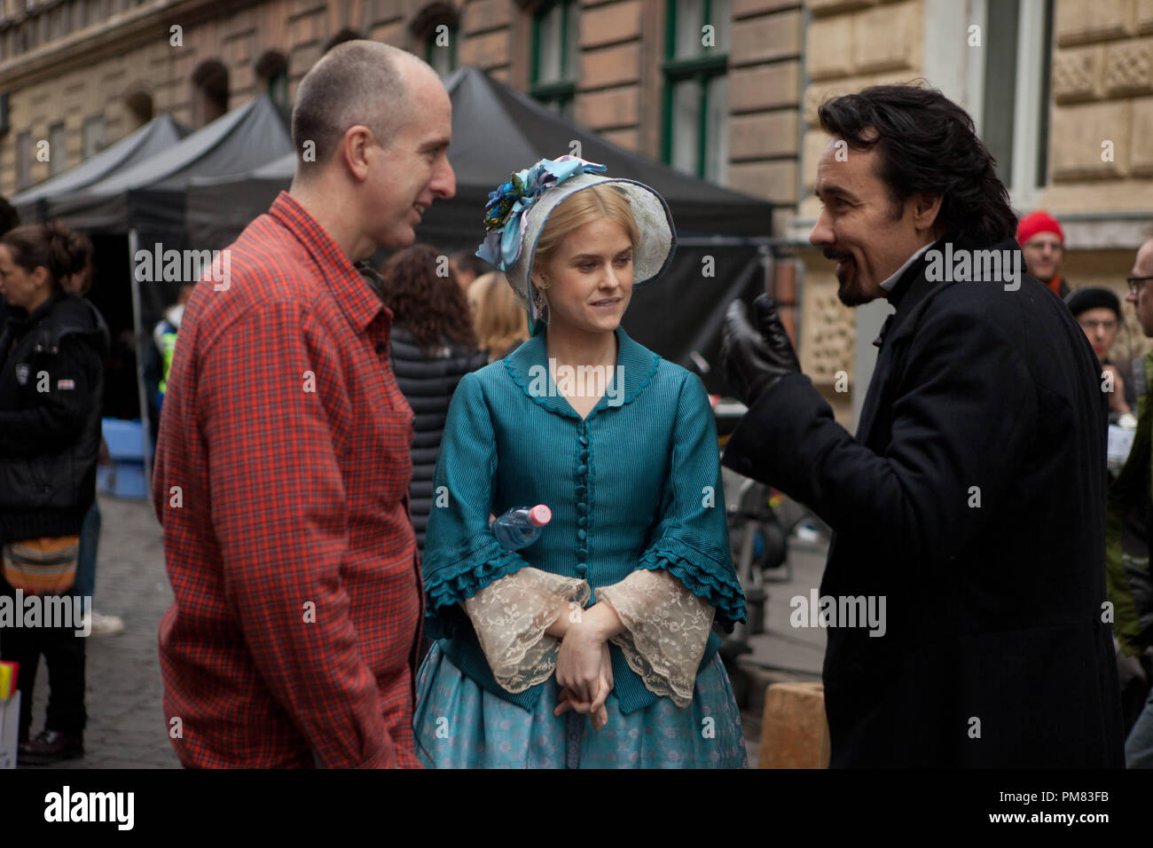 (Left to right.)  Director James McTeigue discusses a scene with stars Alice Eve and John Cusack on the set of Relativity Media's stylish gothic thriller The Raven. Stock Photo