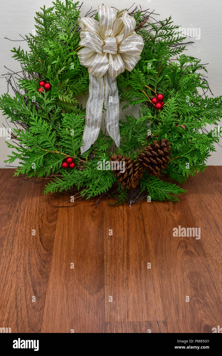 A Christmas wreath with cedar branches, pine cones and red berry ...