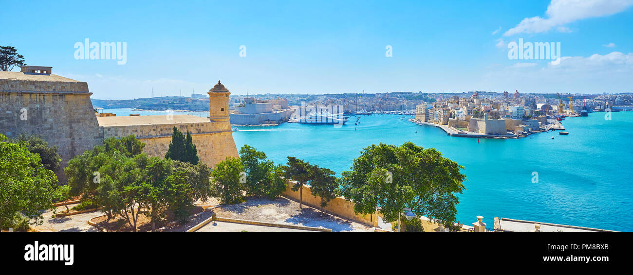 Medieval fortified cities of Birgu and Senglea, surrounded by blue waters of Grand Harbour with small tower of St Peter and Paul counterguard on the f Stock Photo