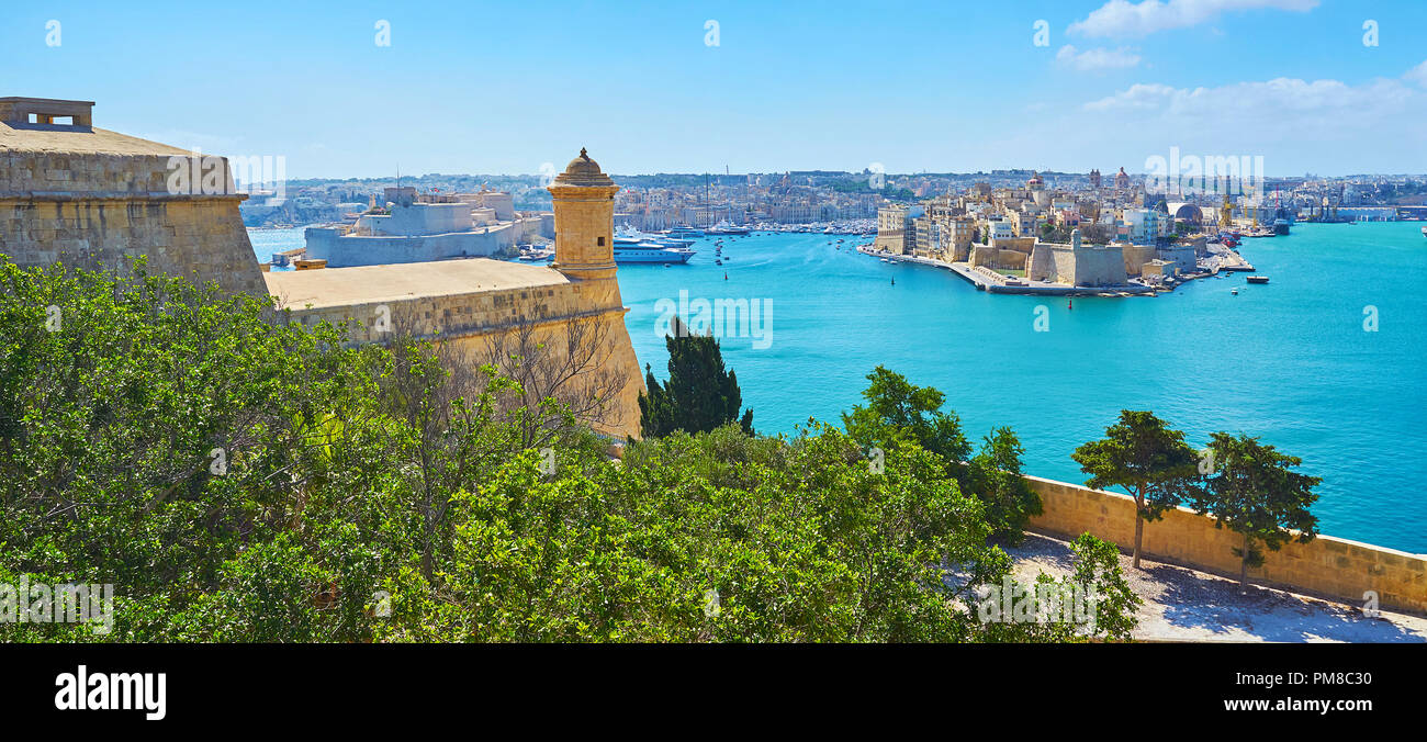The green trees of Herbert Ganado Gardens hide the massive wall of St Peter and Paul counterguard, facing the Grand Harbour of Valletta with medieval  Stock Photo