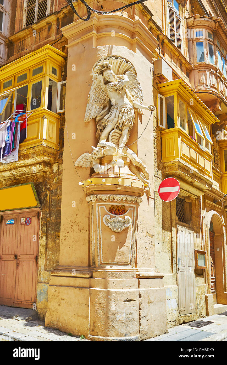 The masterpiece niche of St Michael the Archangel, vanquishing the devil, decorates the corner of Archbishop and St Ursula streets in Valletta, Malta. Stock Photo