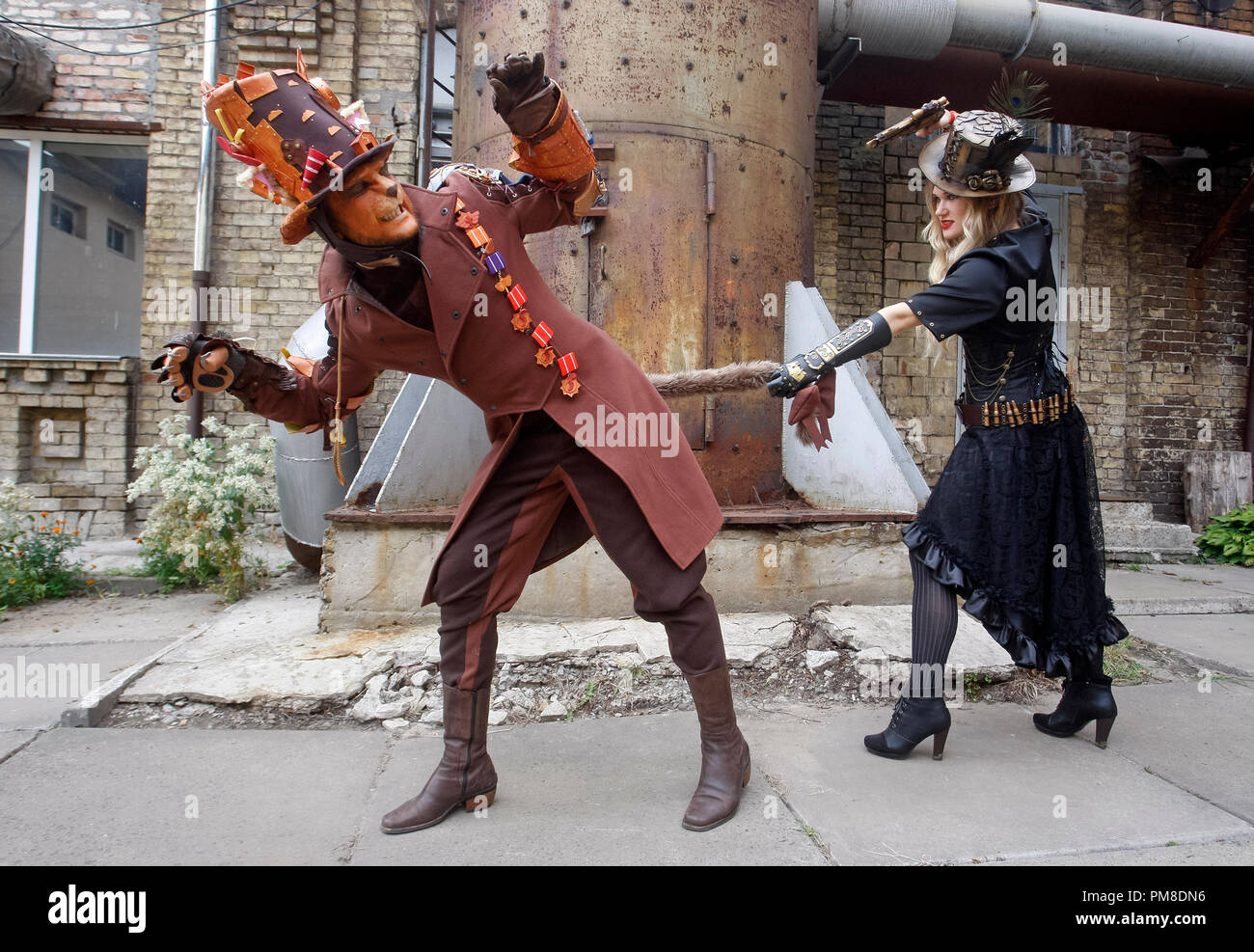 A couple wearing steampunk costumes is seen performing during 'VI KyivSteamCon' event in Kiev. The Steampunk festival involving workshops, talks, competitions, dances and lectures attracts fans of subgenre steampunk, cosplay and science fiction. Stock Photo