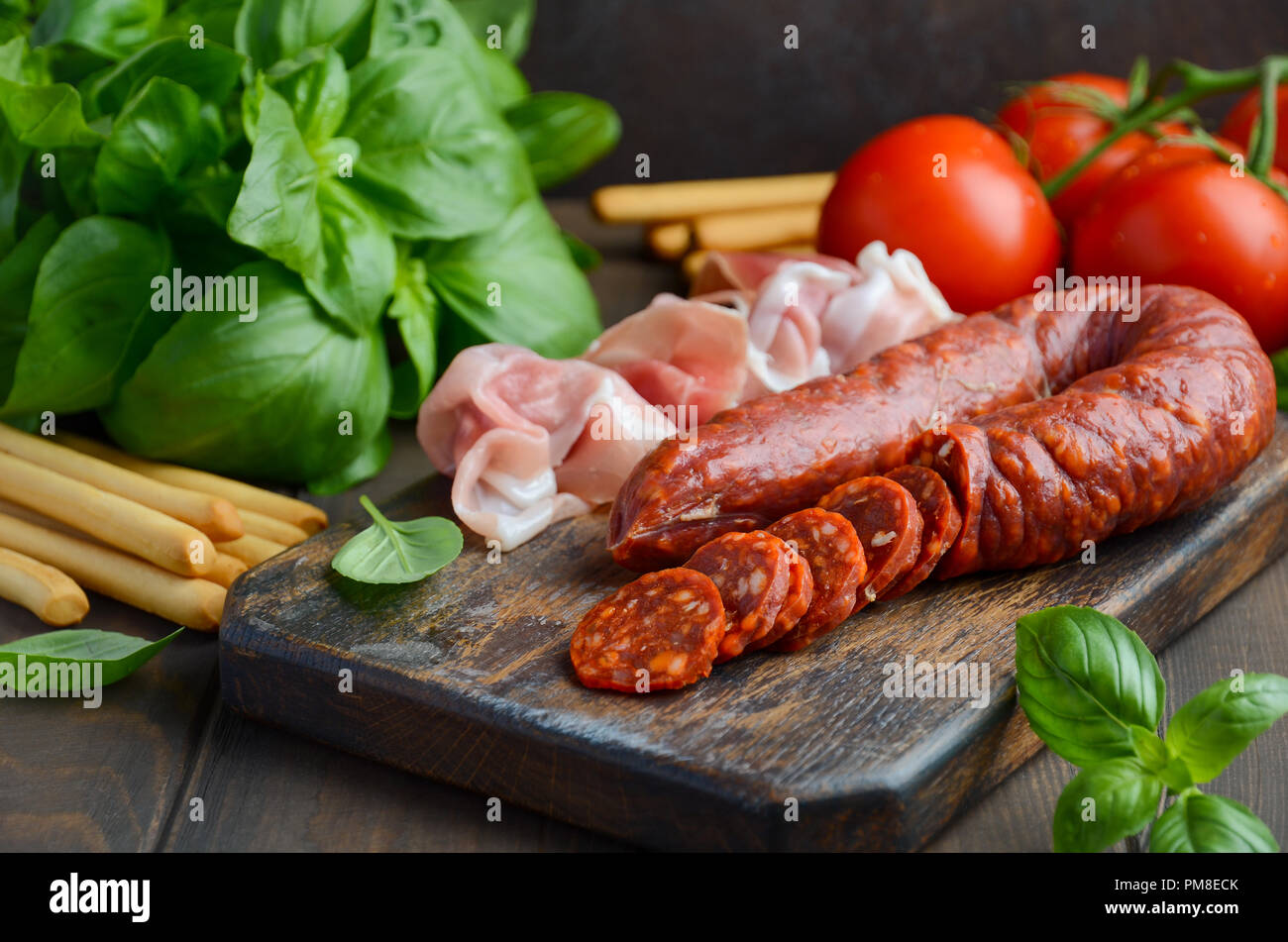 Chorizo sausage. Spanish traditional chorizo sausage with fresh herbs and tomatoes. Stock Photo