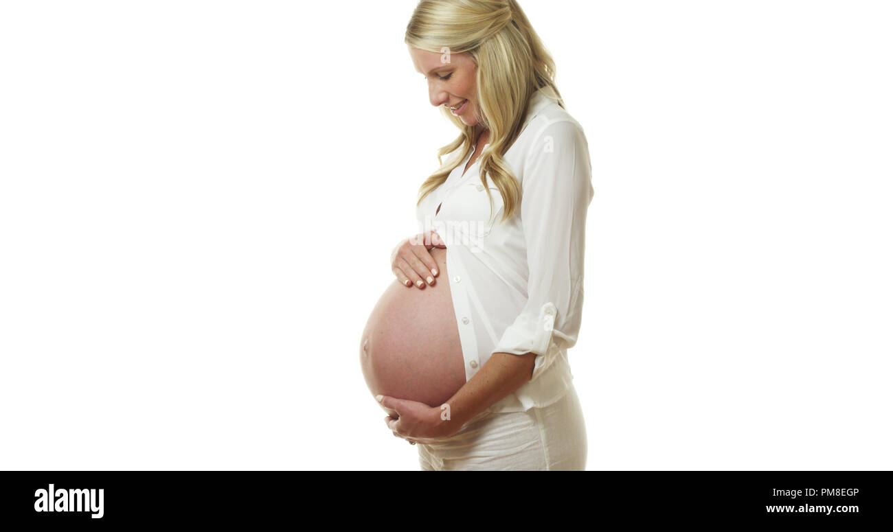 Beautiful pregnant mother standing and holding belly Stock Photo
