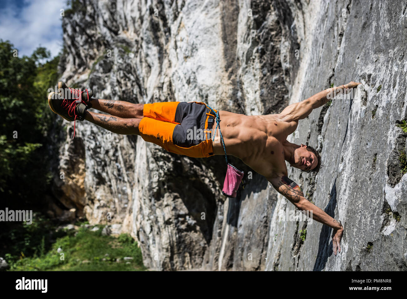 Athlete is performing a flag on the all of a rocky hill Stock Photo