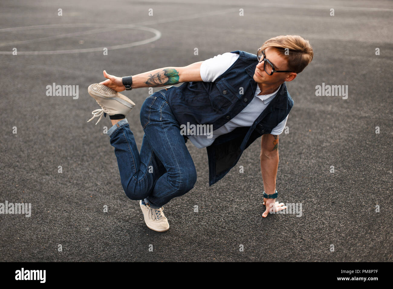 Young handsome man in stylish denim dress dancing hip hop Stock Photo
