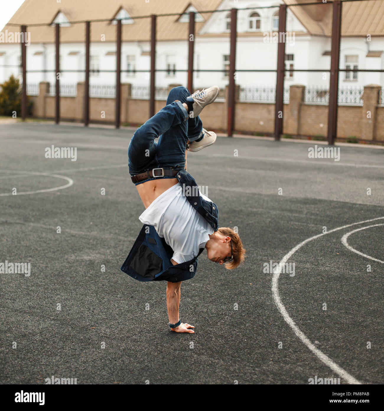 Young handsome man in stylish denim dress dancing hip hop Stock Photo