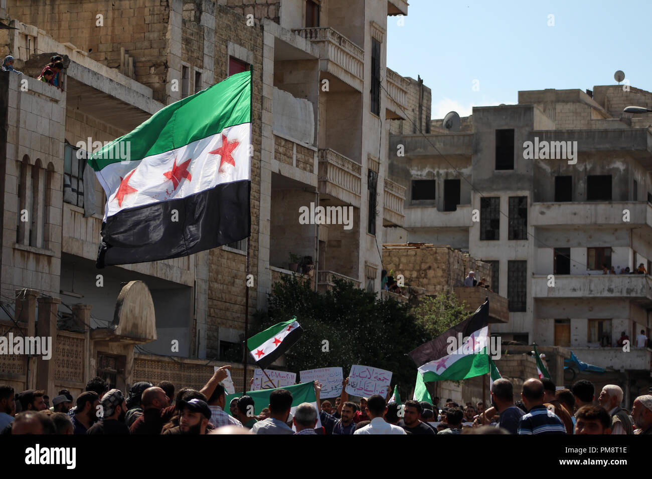 A huge Syrian flag seen waving among protesters during the protest against the Syrian regime. Hundreds of protesters came out in Idlib city on with the slogan of no alternative to toppling the regime and the demonstrators chanting and cheering we are civilians and we want freedom and we don’t want the Syrian regime. Stock Photo