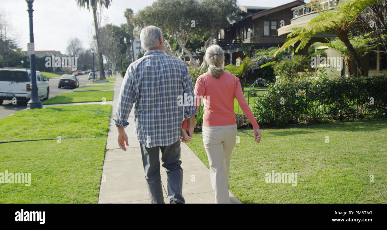 Senior couple walking through neighborhood Stock Photo