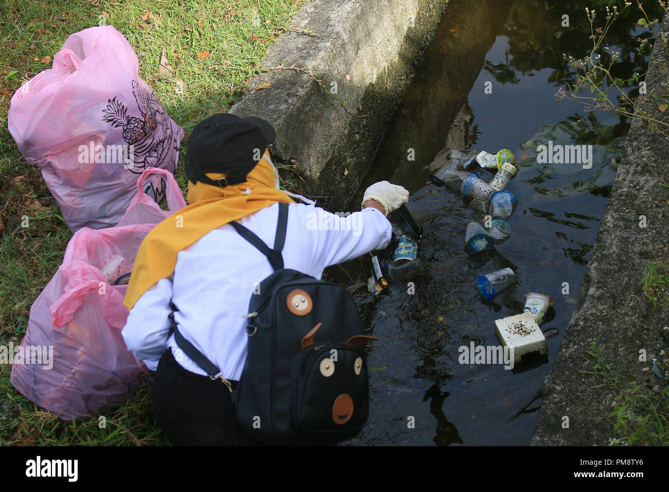 Female volunteers seen cleaning up the waste from the drainage. World Cleanup Day is a global social action program that aims to combat global waste problems. Today there are 157 countries, 380 million volunteers around the world taking part of cleaning up trashes from road sides and drainage. Stock Photo