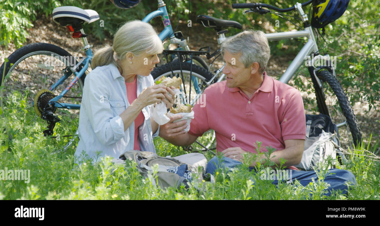 Senior couple having lunch after bike ride Stock Photo