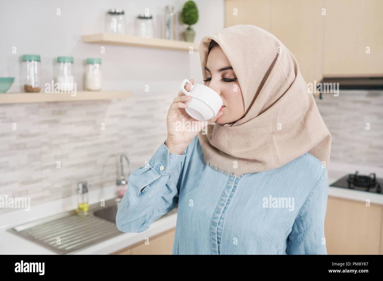 beautiful young woman wearing hijab drinking a cup of coffee Stock ...