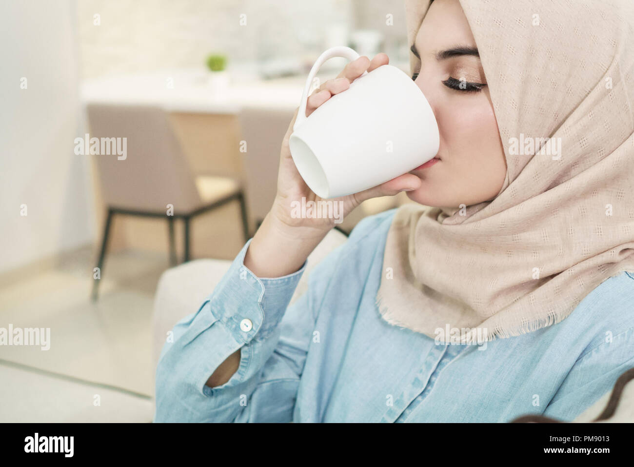 beautiful young woman wearing hijab drinking a cup of tea at liv Stock ...