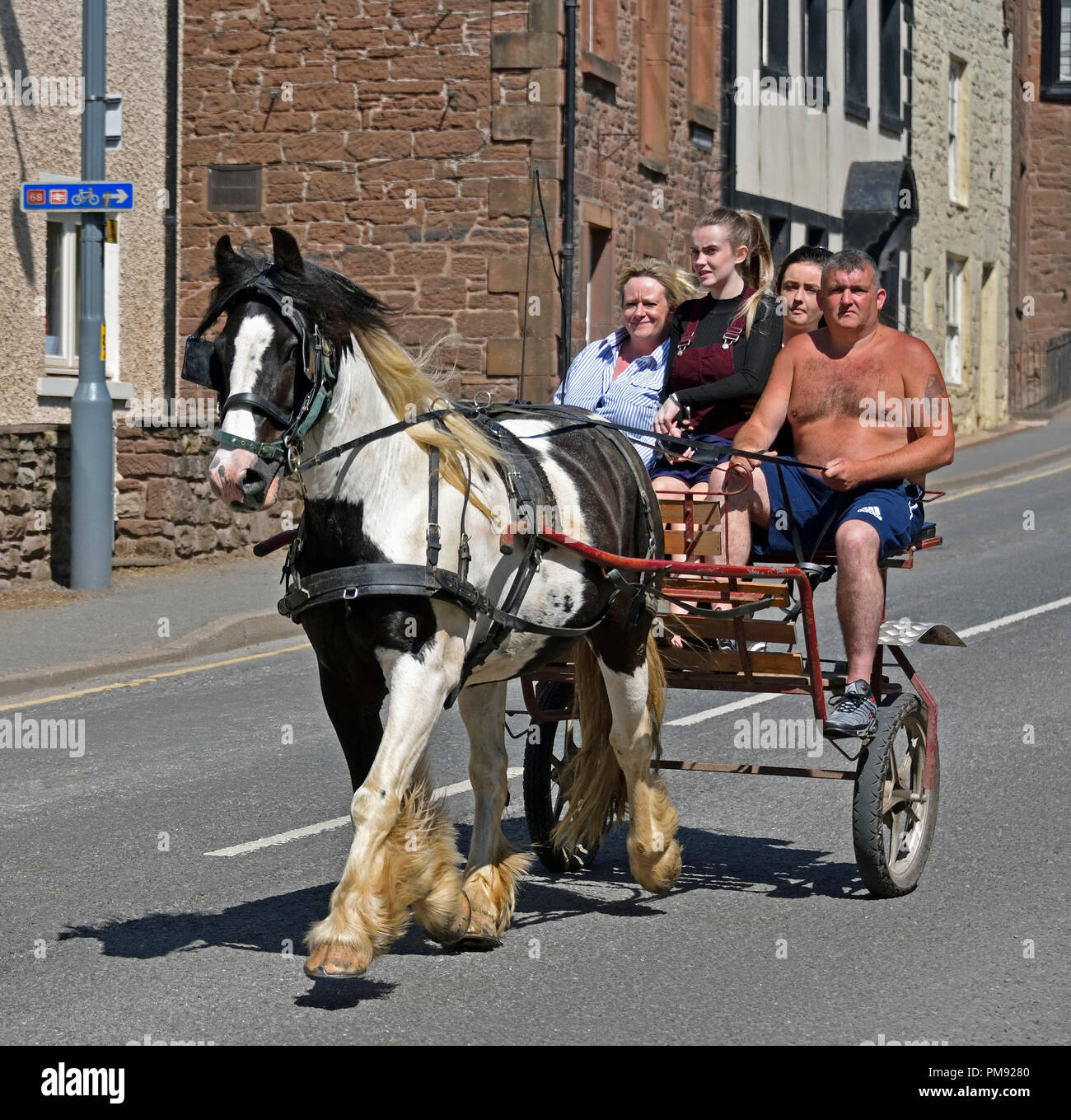 Gypsy Traveller family riding on trotting cart. Appleby Horse Fair 2018. The Sands, Appleby-in-Westmorland, Cumbria, England, United Kingdom, Europe. Stock Photo