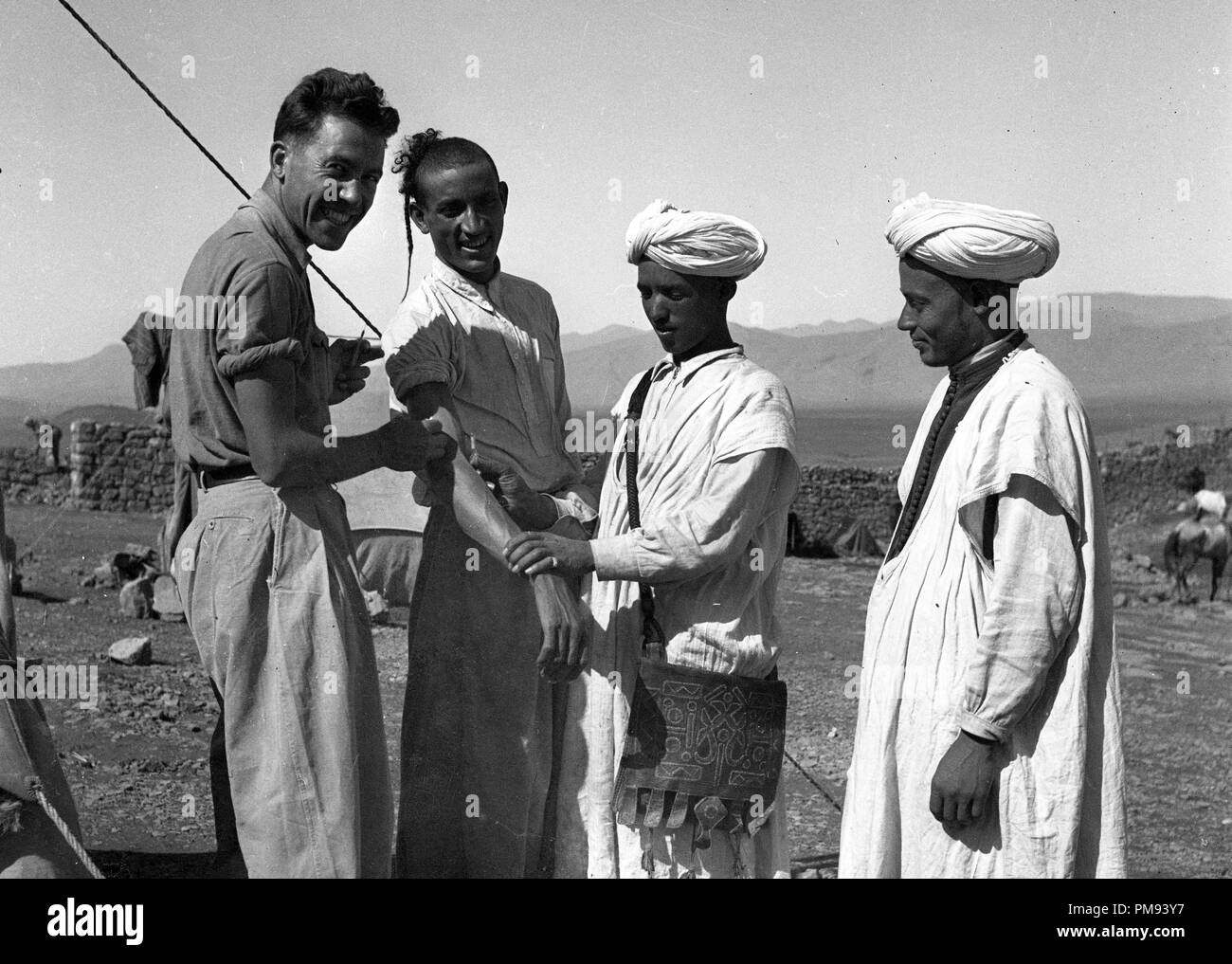 Morocco 1930s French Foreign Legion soldier inoculating vaccine to local tribesmen Stock Photo