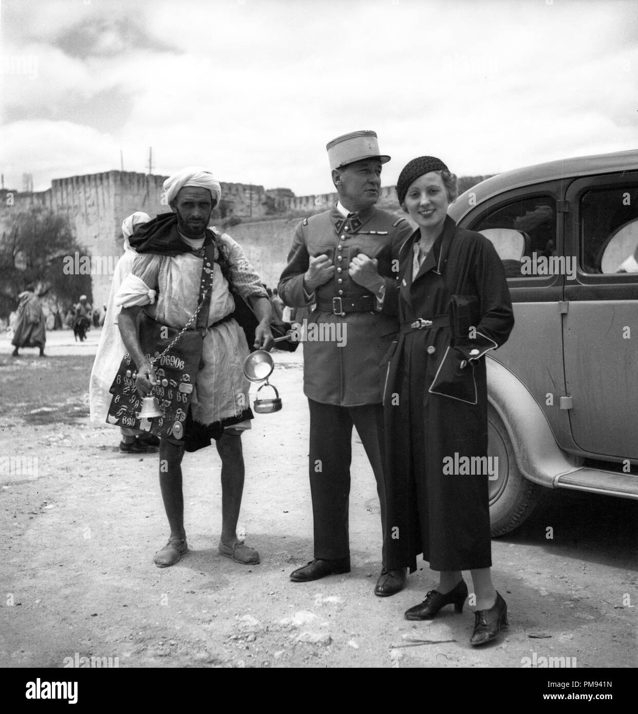 Morocco 1930s French Foreign Legion soldier and smartly dressed woman with local man selling goods Stock Photo
