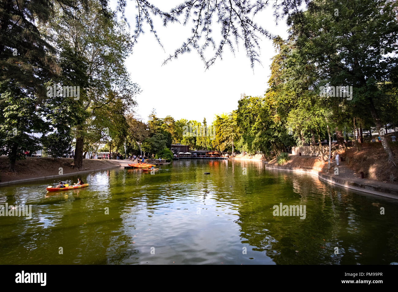 lake inside an urban park at the city of Braga, with some people on paddling caiaques Stock Photo