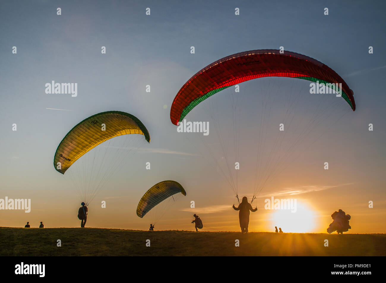 Eastbourne, East Sussex, UK..17 September 2018..A warm breeze from the South brings paraglider pilots to Beachy Head on the beautiful Sussex Downs. . Stock Photo