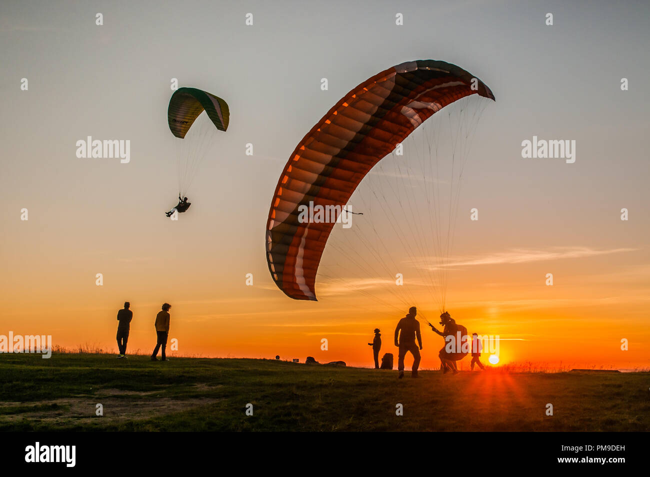Eastbourne, East Sussex, UK..17 September 2018..A warm breeze from the South brings paraglider pilots to Beachy Head in the beautiful Sussex Downs. . Stock Photo