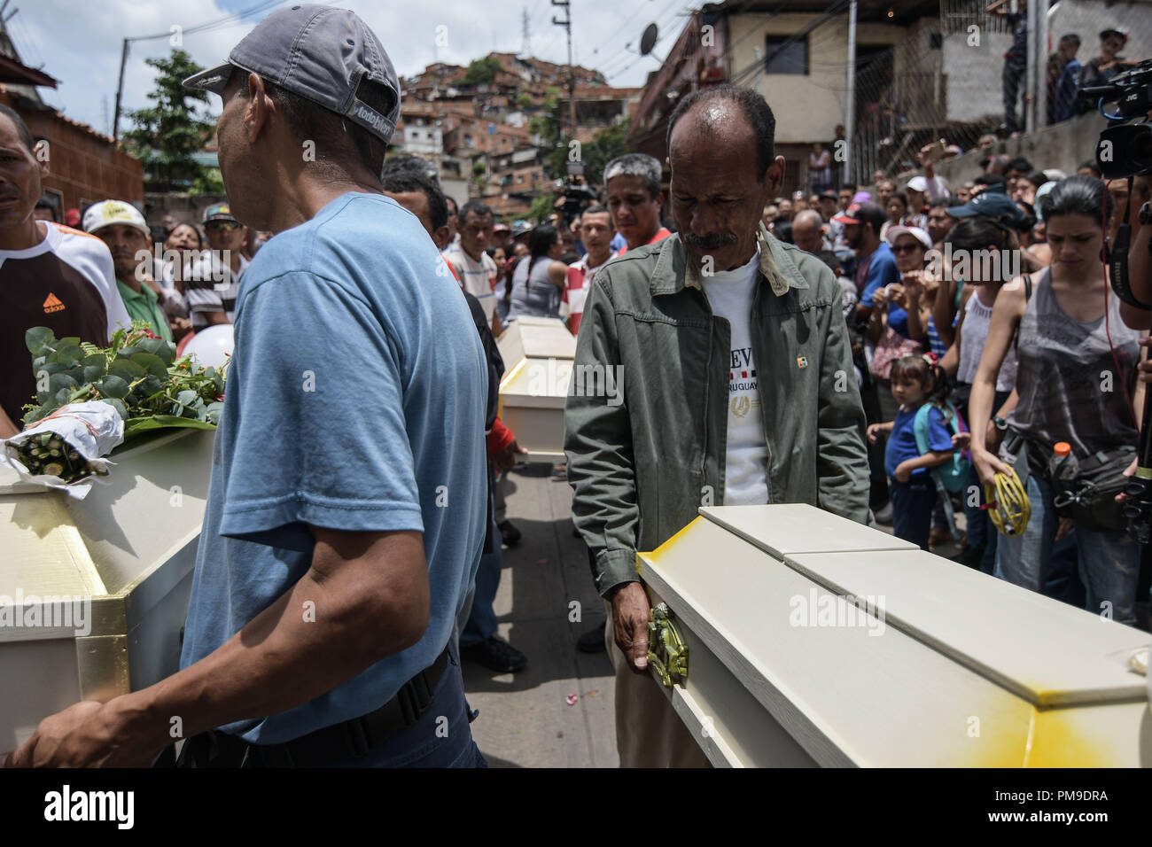 Caracas, Distrito Capital, Venezuela. 17th Sep, 2018. Relatives seen carrying the coffins of the victims during the funeral. The victims, Roxana Conde (10 years old), Julianyerli Conde (4 years old), JonÃ¡s Jonneiker Conde (1 year old) and Humberto Ruiz (10 years old), were murdered last September 14th in El 70 in Caracas, Venezuela. The perpetrator was identified as José Manuel Morgado (48 years old) who was killed the same night after a shootout with police officers (CICPC) while fleeing in Ocumare del Tuy, Miranda state, Venezuela. The suspect raped the children before killing them Stock Photo