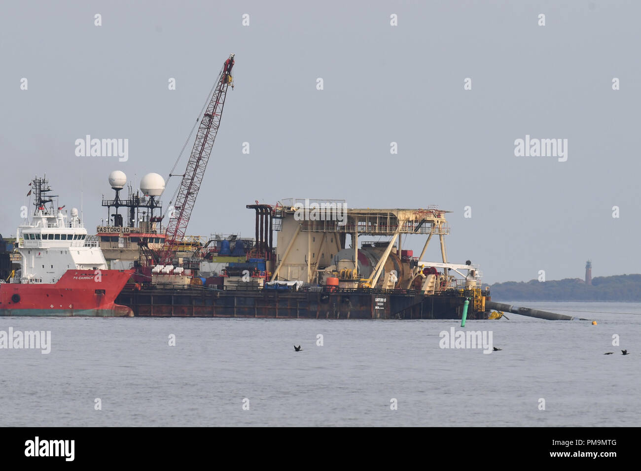 17 September 2018, Mecklenburg-Western Pomerania, Thiessow: The pipeline laying vessel 'Castoro 10' (r) is laying pipes for the Baltic Sea natural gas pipeline Nord Stream 2 between the island of Rügen and the island of Greifswalder Oie. The 1,200-kilometer gas pipeline will transport around 55 billion cubic meters of Russian natural gas from Russia to Germany every year from the end of 2019. Photo: Stefan Sauer/dpa-Zentralbild/dpa Stock Photo
