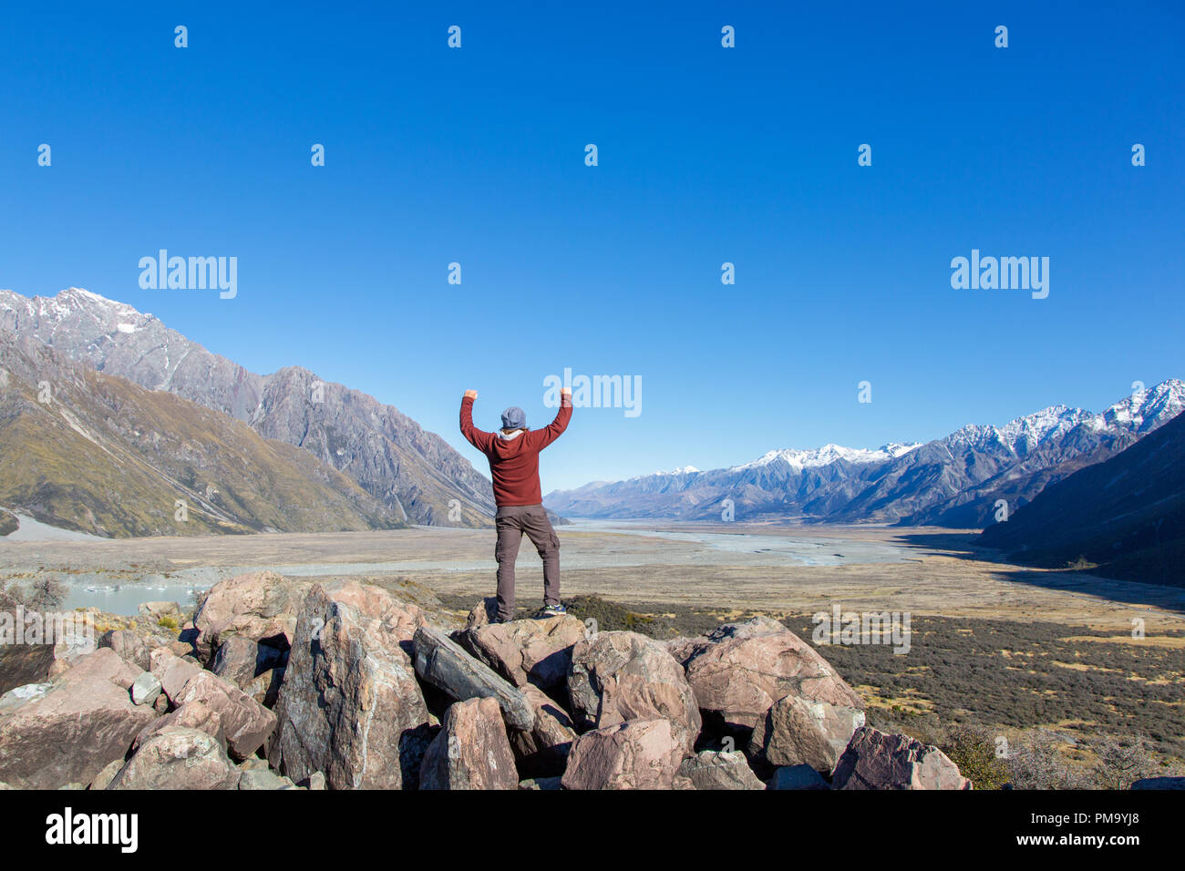 Person is posing in Aoraki- Mount Cook Nationalpark in front of a wide valley, New Zealand, South Island Stock Photo