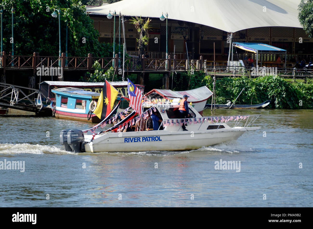 River patrol boat on the Sarak Rivr carrying Sarawak and Malaysian flags in KUching, Gawai regatta and festival, Borneo Stock Photo