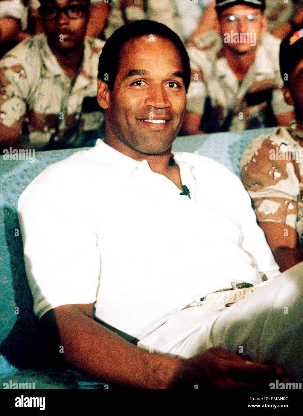 NBC Sports commentator and former professional football player O.J. Simpson sits with a group of servicemen to watch a Thanksgiving Day football game.  Simpson is visiting U.S. troops who are in the region for Operation Desert Shield, 1990.  File Reference # 32733 351BTHA Stock Photo