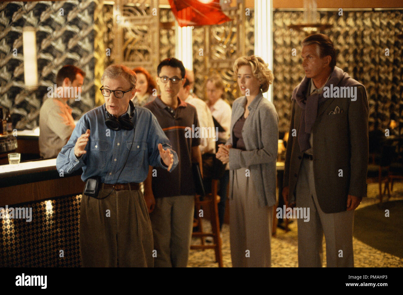 Director Val Waxman (WOODY ALLEN, left) is trying to describe what he envisions for the next scene to (left to right) his cinematographer's translator (BARNEY CHENG) and studio executives Ellie (TÉA LEONI) and Ed (GEORGE HAMILTON) in Woody Allen's latest contemporary comedy 'Hollywood Ending' (2002), being distributed domestically by DreamWorks. Stock Photo