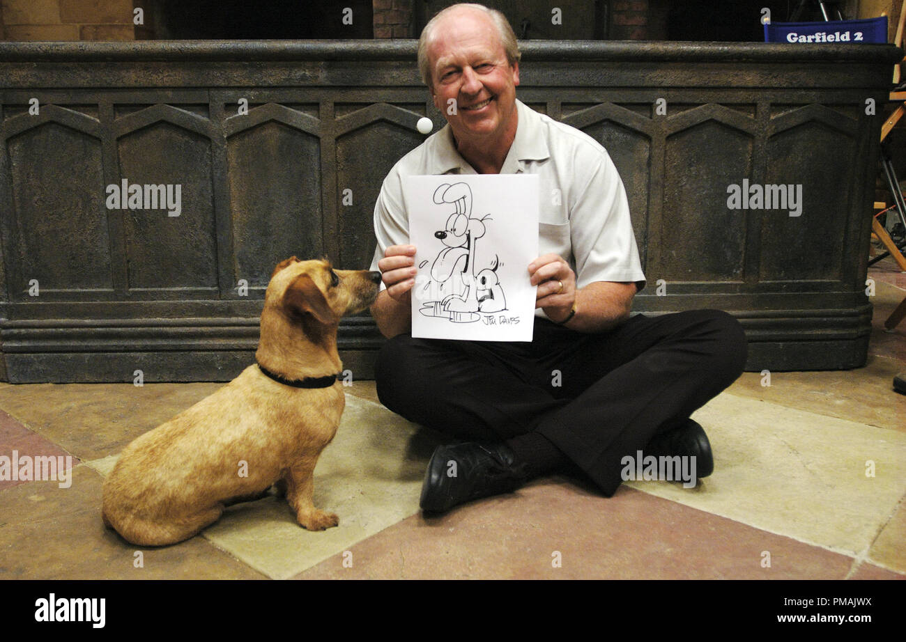On the set of GARFIELD: A TAIL OF TWO KITTIES, Garfield creator Jim Davis displays a drawing of Odie, as the on-screen Odie looks on.  'GARFIELD: A TAIL OF TWO KITTIES' (2006) Twentieth Century Fox. Stock Photo