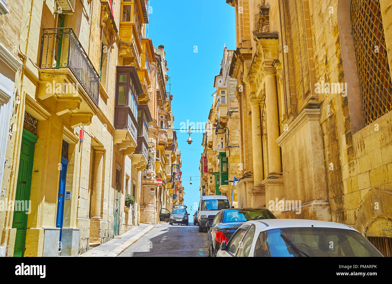 Walk along the ascent in St Ursula street with a view on historical housing and colored Maltese balconies, Valletta, Malta. Stock Photo