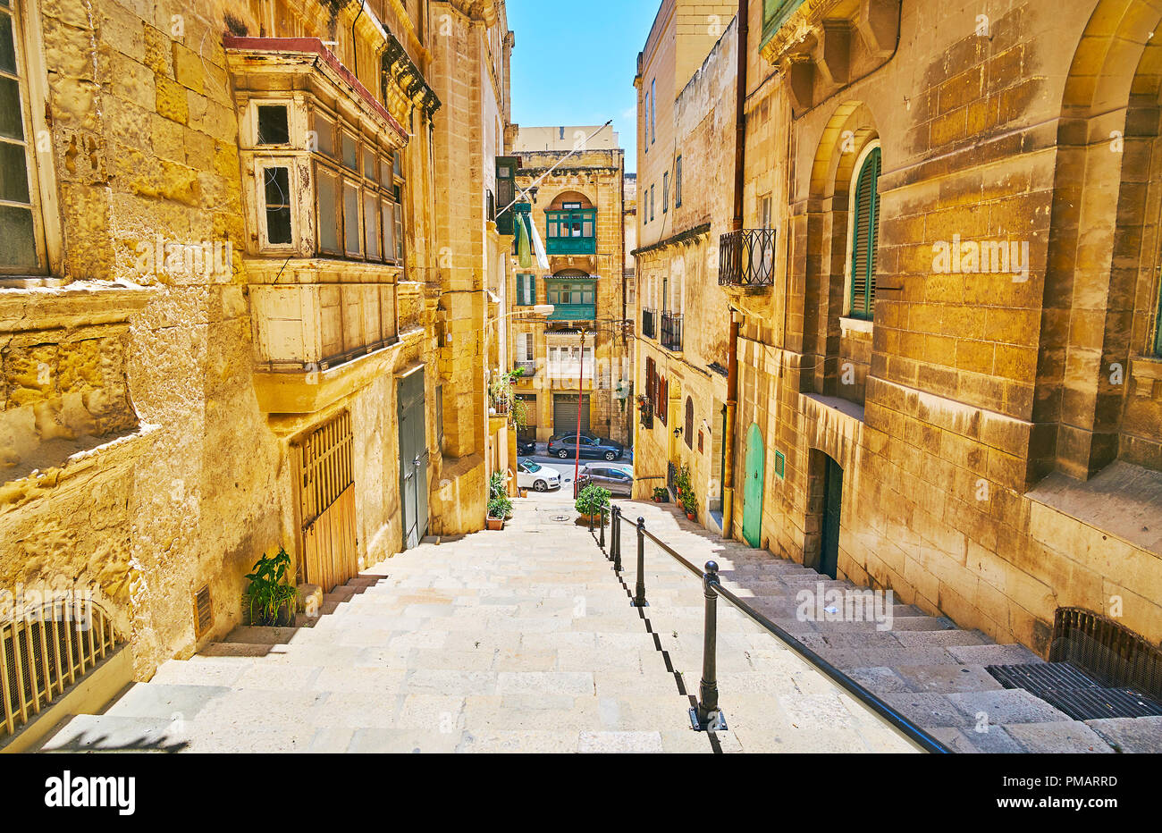 The stone staircase stretches along the narrow St Lucia street lined with old edifices, Valletta, Malta. Stock Photo