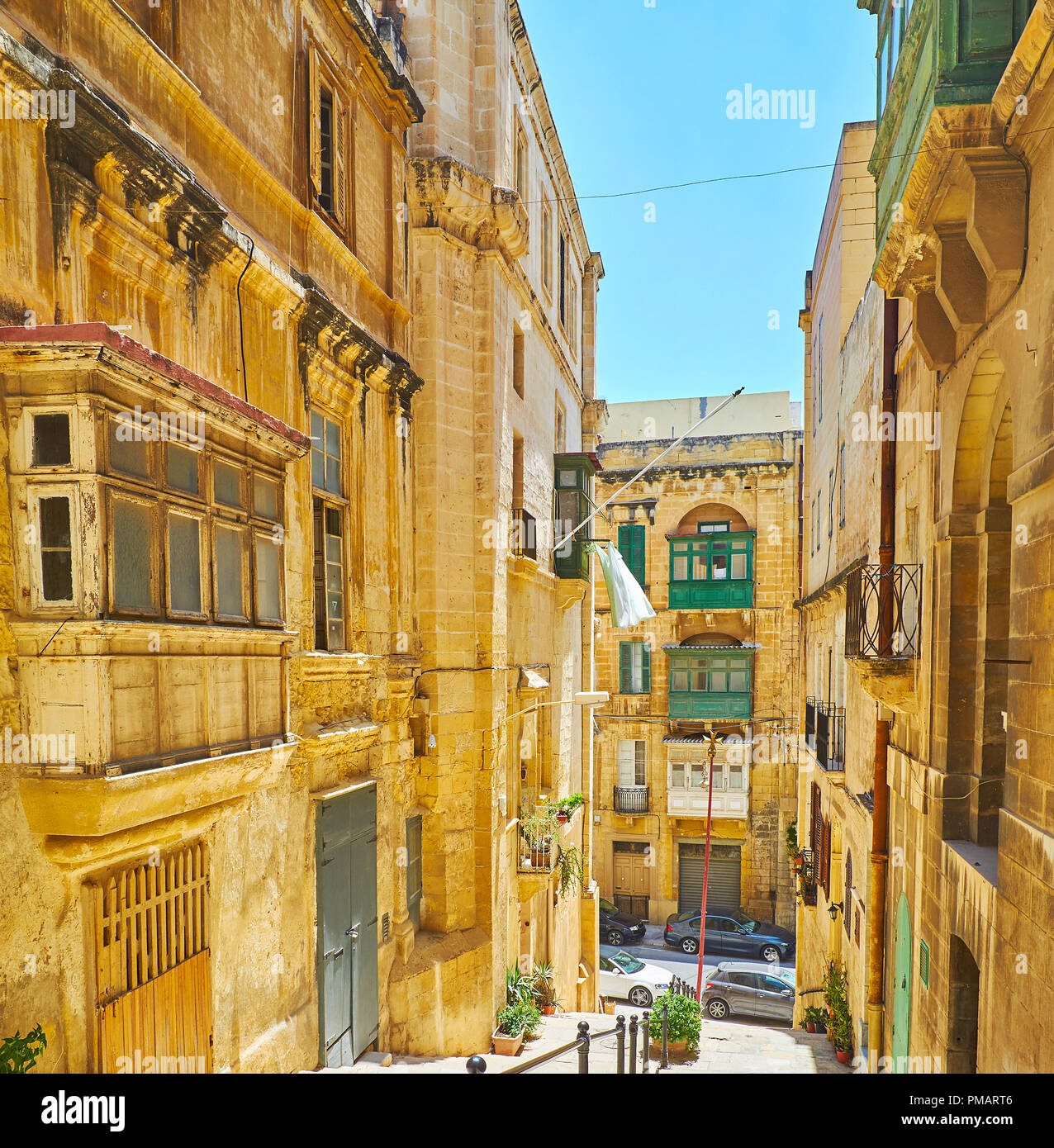 The narrow stone St Lucia street is quiet and empty on midday, Valletta, Malta. Stock Photo